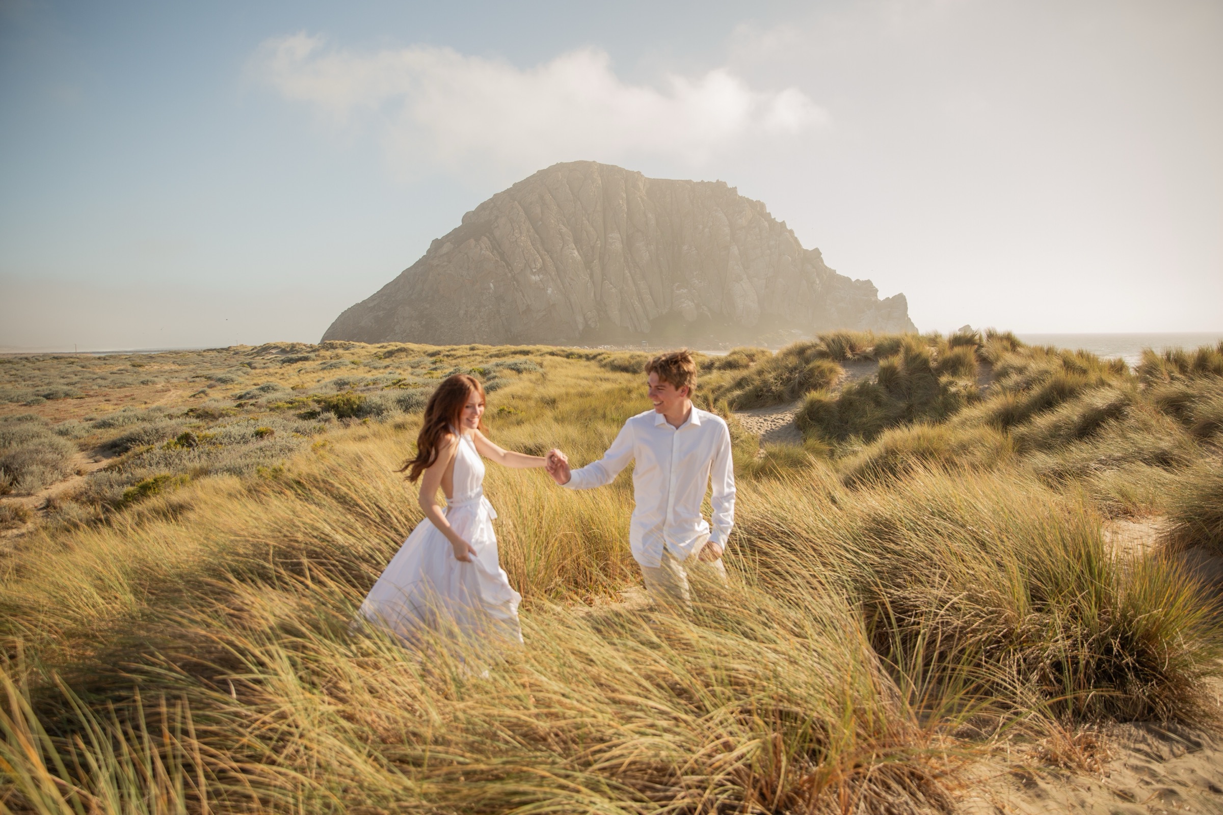 Bridget and Cole walking together through coastal grassland