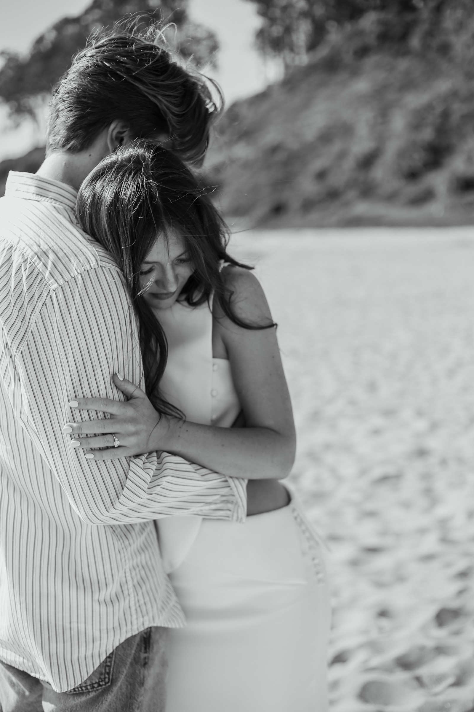 Bridget and Cole embracing on the beach